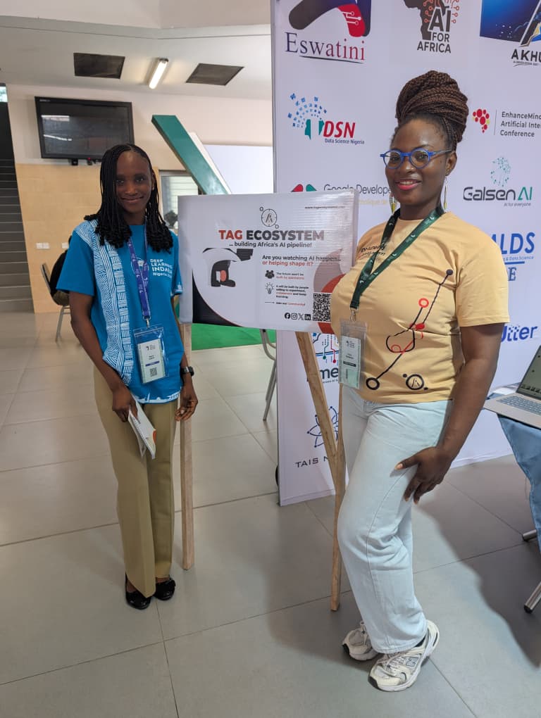 TAG Ecosystem members standing by the community signboard at Deep Learning Indaba Nigeria 2026