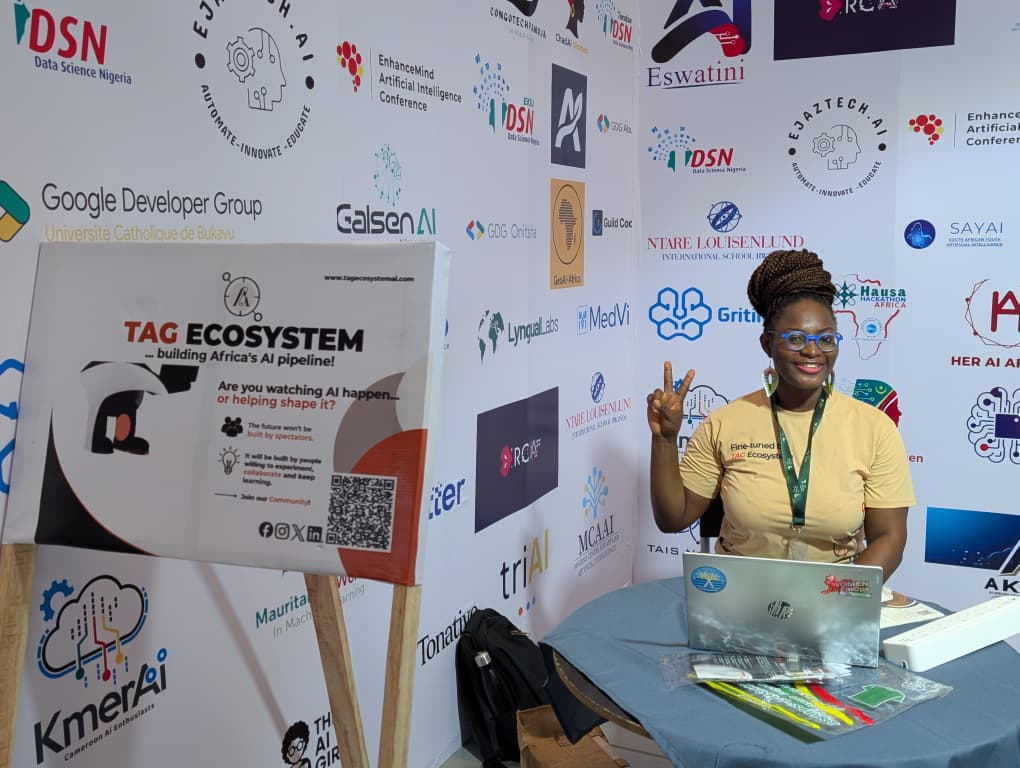 A TAG Ecosystem community member at the booth table with the community signboard