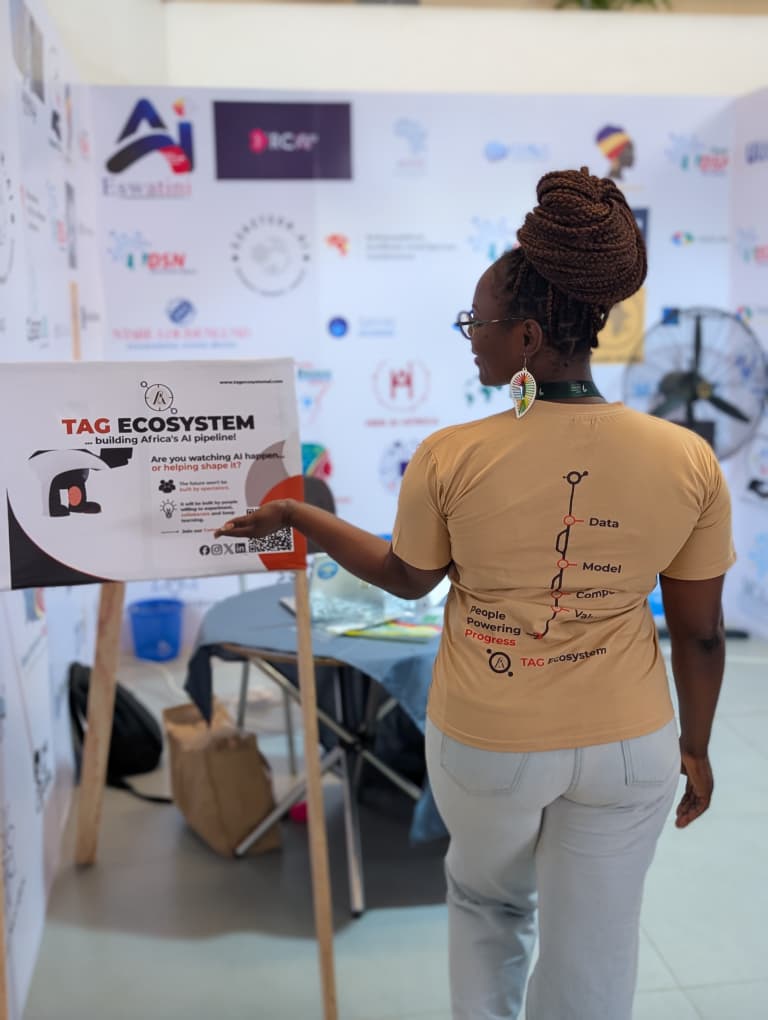 A TAG Ecosystem community member introducing the community signboard to a visitor
