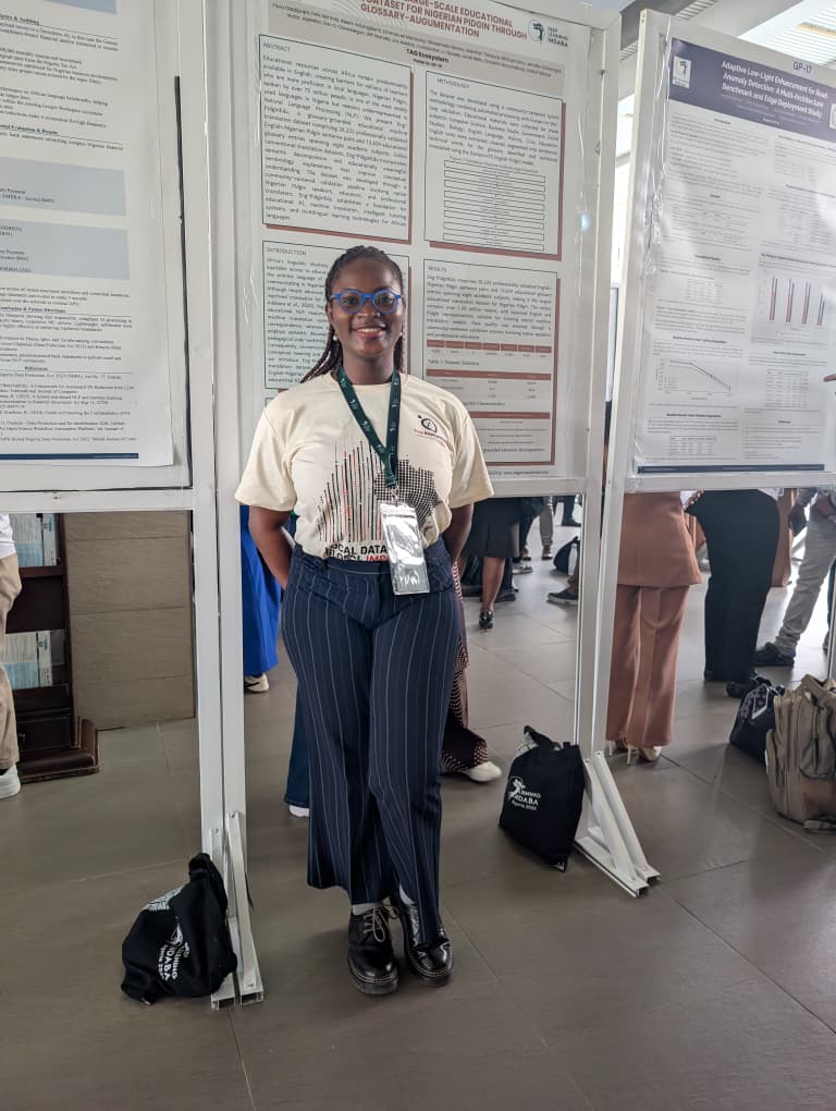 Flora Oladipupo at the Eng-PidginEdu poster station among the Deep Learning Indaba 2026 poster hall